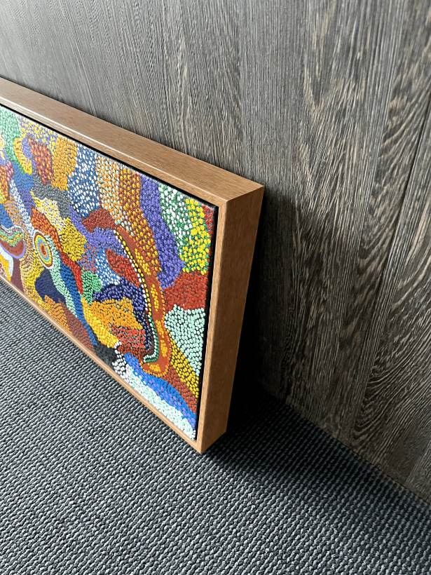 Close-up of a timber float frame showing the gap around a dot painting