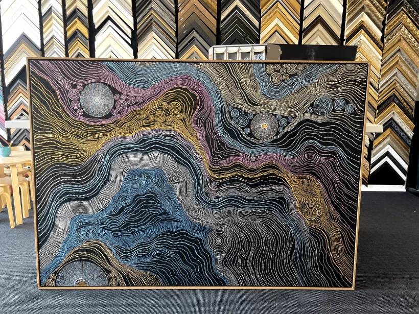 Float-framed painting leaning against the moulding wall