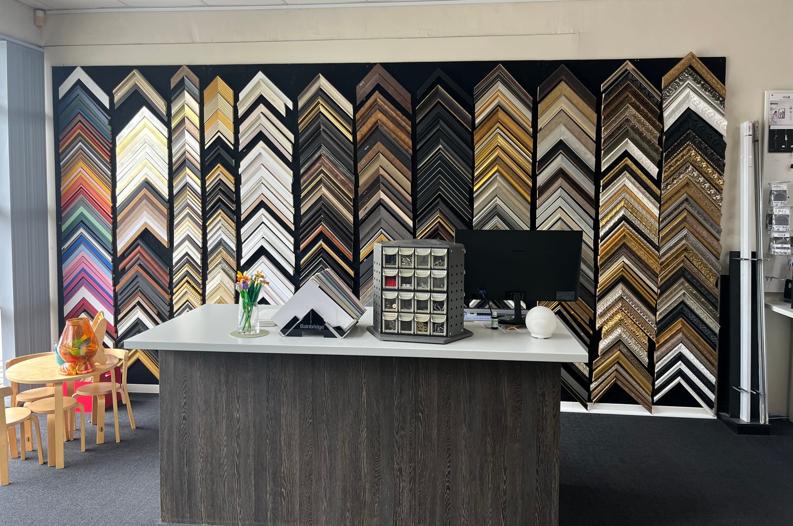 Rows of timber, black, white and decorative frame samples at the showroom counter